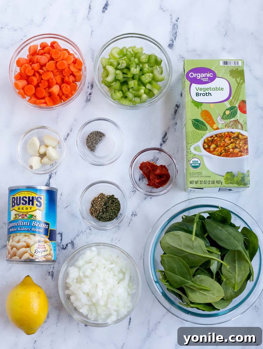 A top-down view of neatly arranged fresh ingredients on a wooden board, including diced carrots, sliced celery, chopped onions, minced garlic, fresh spinach, canned cannellini beans, a lemon, and various spices, all ready for Tuscan White Bean Soup preparation.