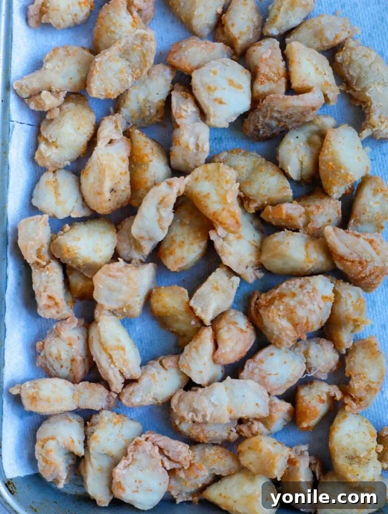No Fuss General Tsos Chicken 7 Cooked chicken pieces set aside on paper towels to drain excess oil.