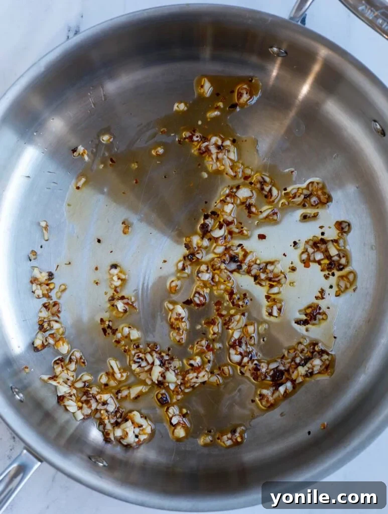 No Fuss General Tsos Chicken 8 Image of sautéing the garlic and chili flakes in a skillet to build flavor for the sauce.