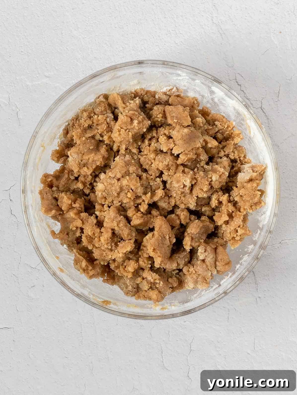 Close-up of a bowl containing a perfectly mixed crumble topping mixture, ready for baking.