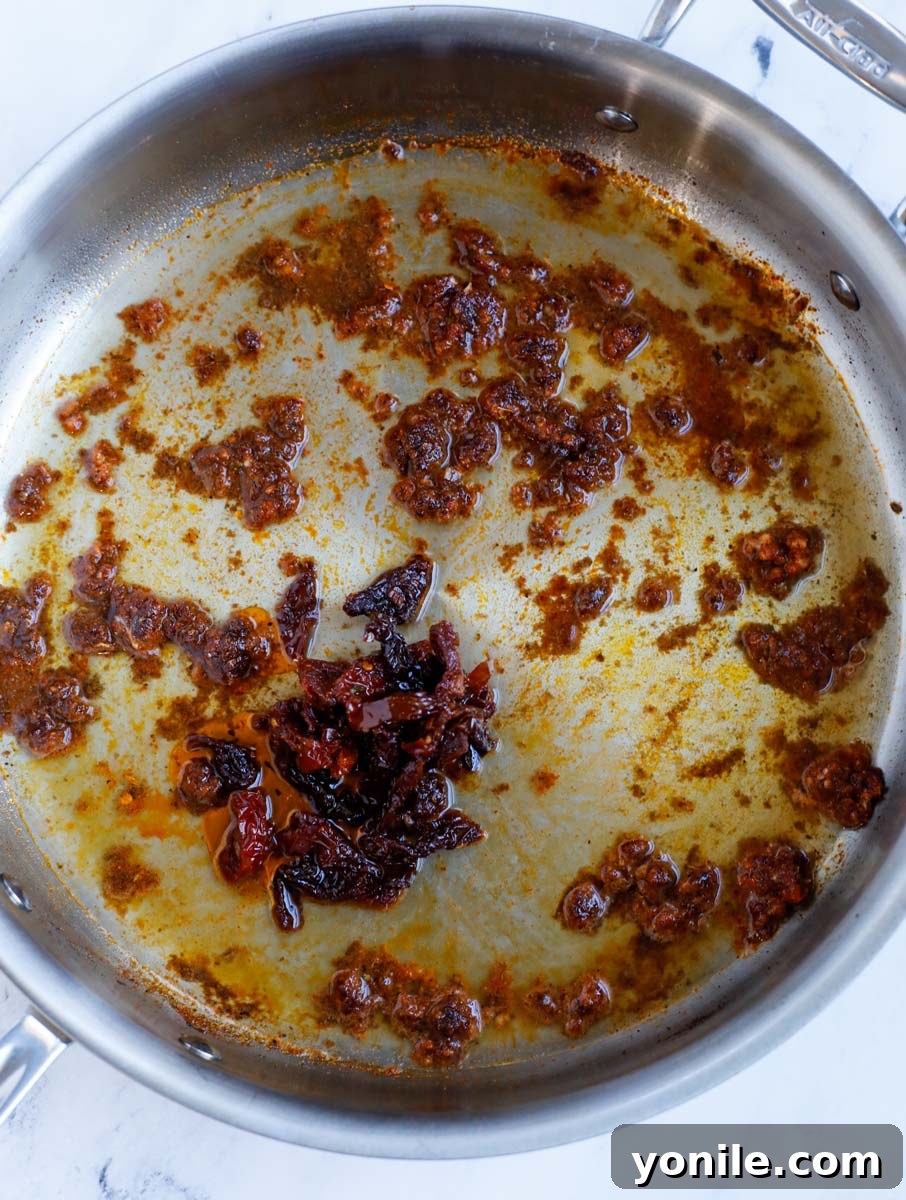 Minced garlic and fragrant Cajun spices being gently sautéed in olive oil within a skillet, releasing their delightful aromas.