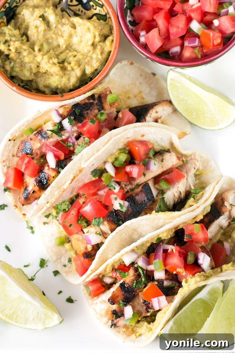Delicious Mexican Chicken Tacos served with fresh guacamole and vibrant pico de gallo, ready to eat.
