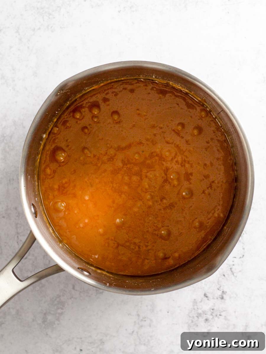 The finished caramel sauce resting in a pot, appearing smooth, thick, and golden, ready for transfer.