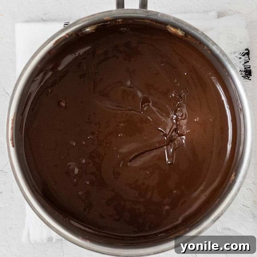 Decadent Chocolate Peanut Butter Oat Bars 6 A saucepan filled with melted chocolate, butter, and peanut butter, forming a luscious topping.
