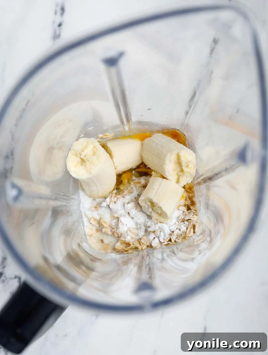 Ingredients for baked oats being added to a blender.