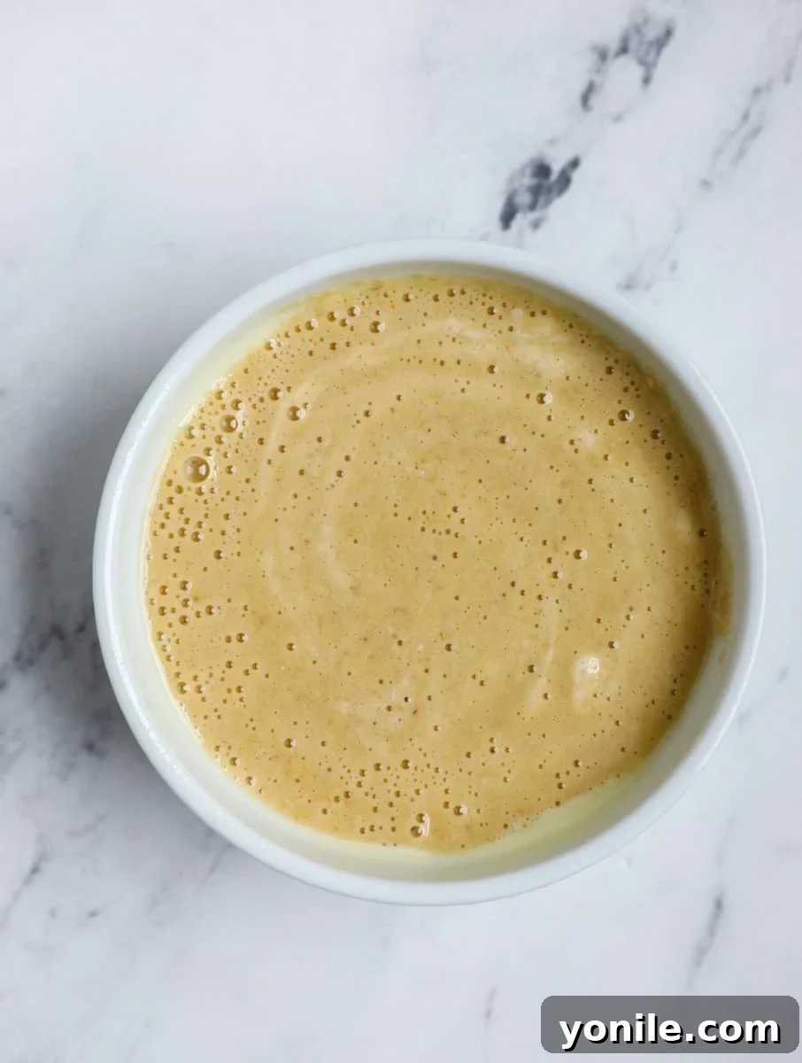 Banana baked oats batter being poured into a ramekin.