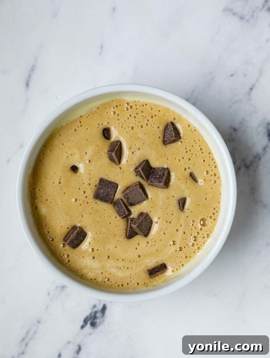 Chocolate chip banana baked oats batter with chocolate chips in a ramekin.