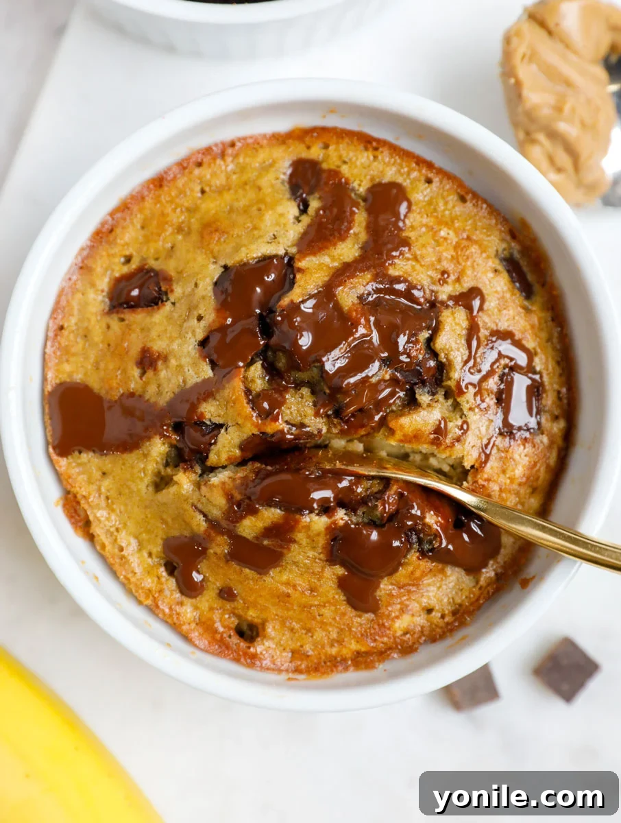 Spoon digging into a ramekin of warm banana chocolate baked oats.