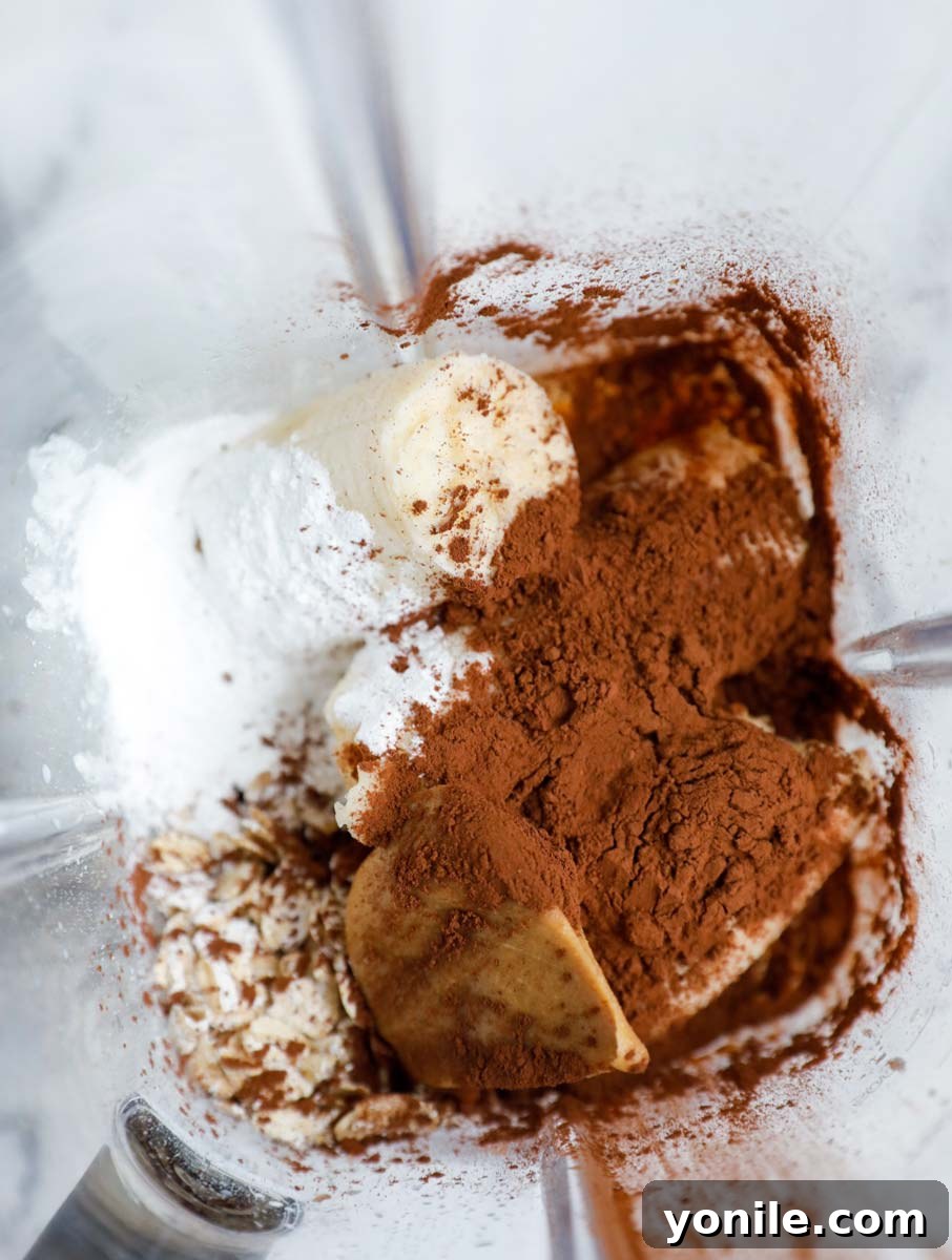 Ingredients for peanut butter chocolate baked oats inside of a blender.