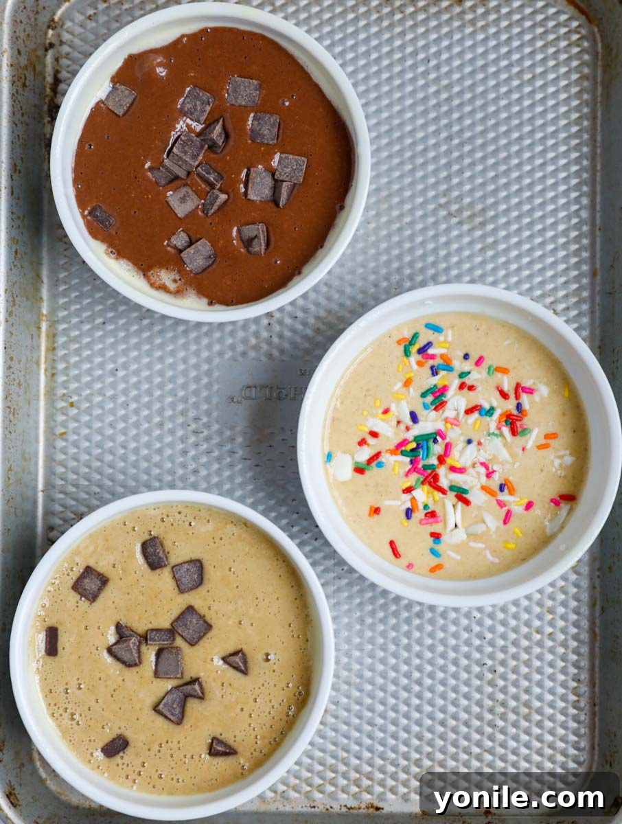 3 Irresistible Baked Oats Recipes 6 A set of three ramekins, each containing the prepared batter for baked oats and ready for baking in the oven.