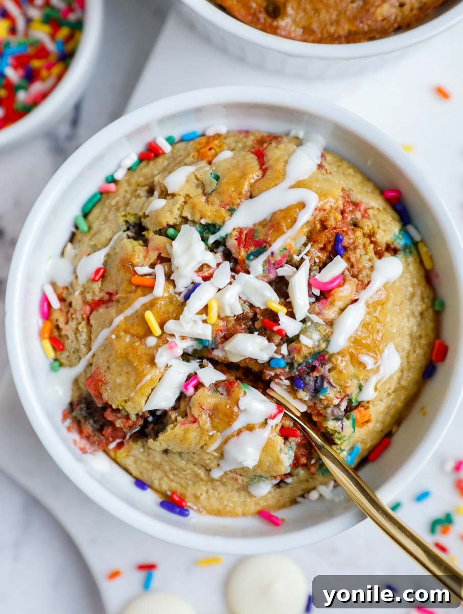 3 Irresistible Baked Oats Recipes 7 A perfectly baked funfetti baked oat cake, adorned with a light frosting and colorful sprinkles, beautifully presented.