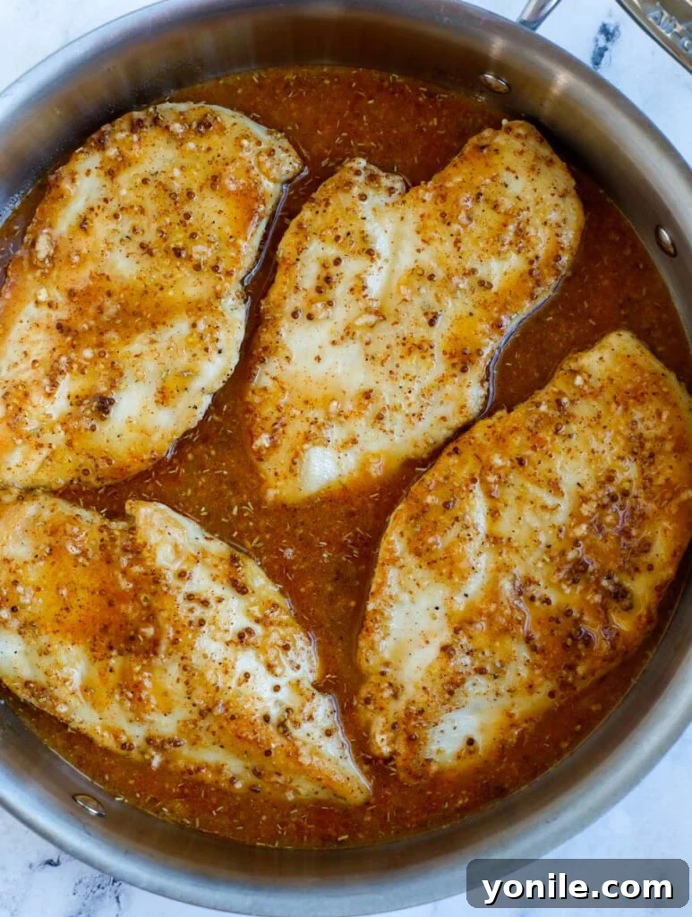 Sweet & Tangy Mustard Chicken 7 The golden-brown chicken breasts nestled in the skillet, with the luscious honey mustard sauce being poured over them.