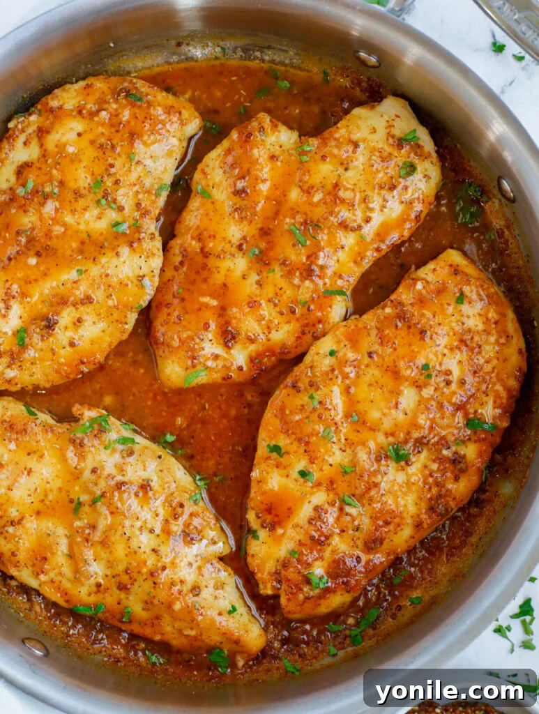 Sweet & Tangy Mustard Chicken 8 The finished honey mustard chicken, glistening with sauce, served directly in the skillet with a sprinkle of fresh herbs, ready for the table.