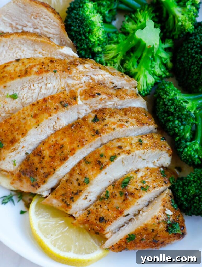 An appetizing close-up of beautifully sliced baked chicken breasts, showing their tender, juicy interior.