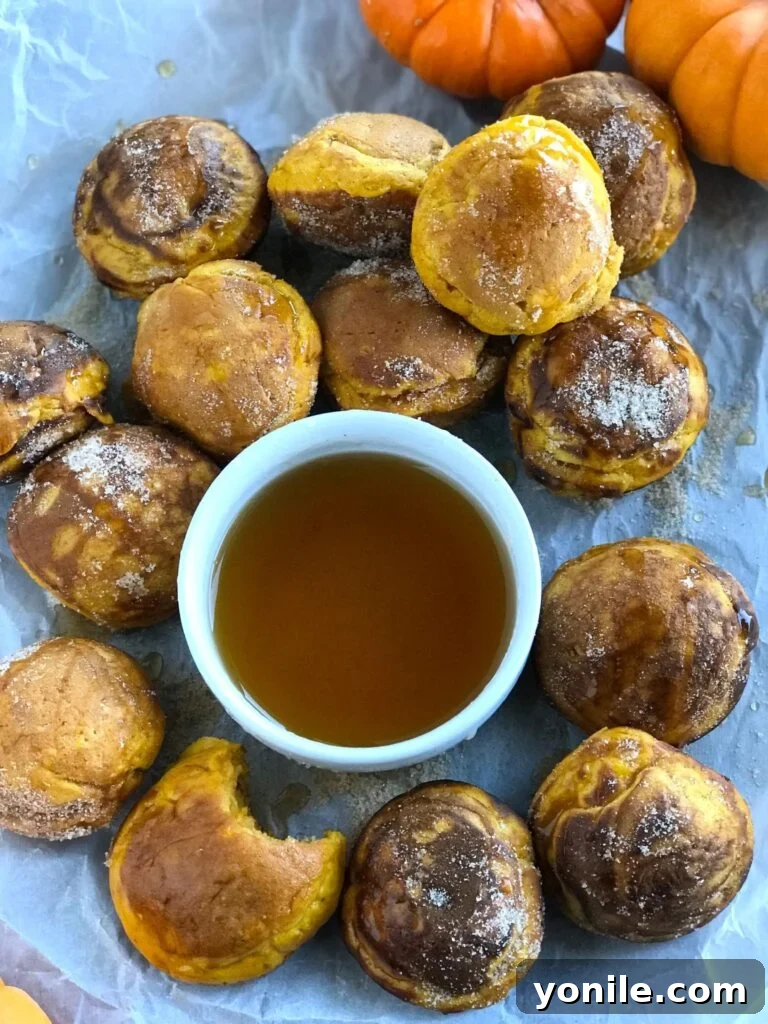 Pumpkin Pancake Bites with a bowl of syrup, ready to be enjoyed as a delightful fall breakfast.