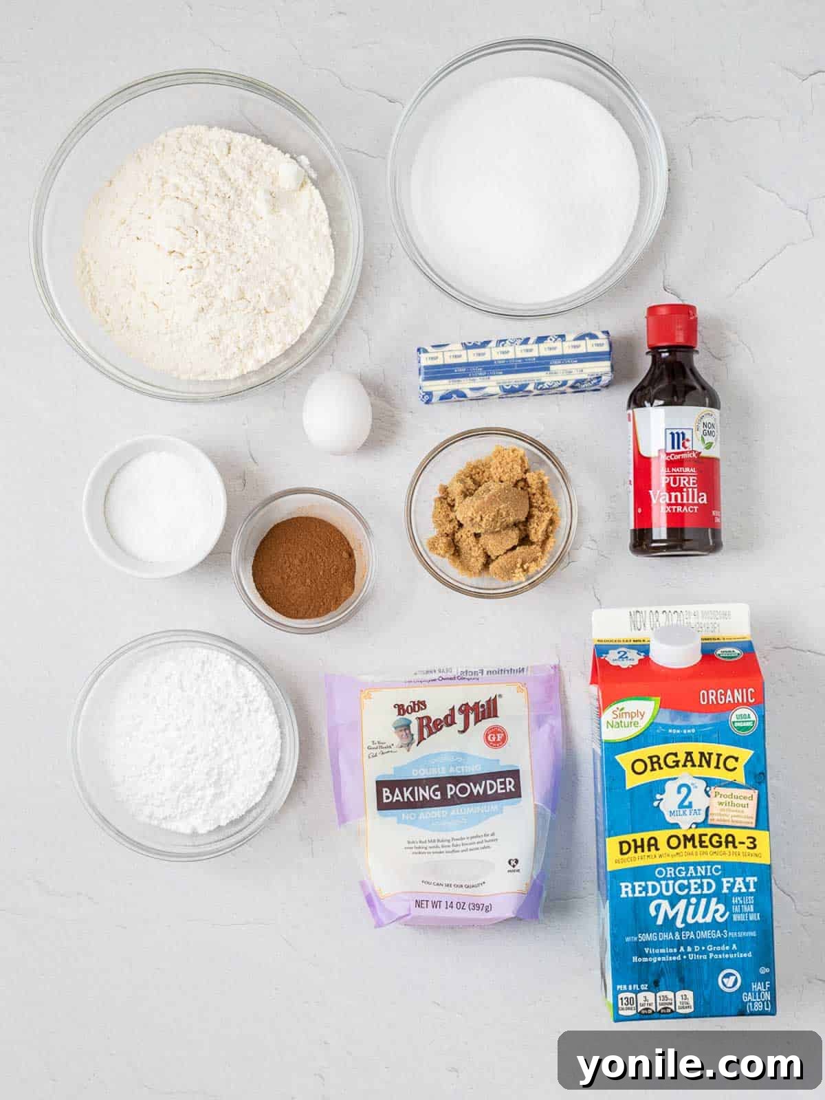 Ingredients for making Cinnamon Streusel Coffee Cake laid out on a table, including flour, sugar, butter, eggs, milk, and cinnamon.