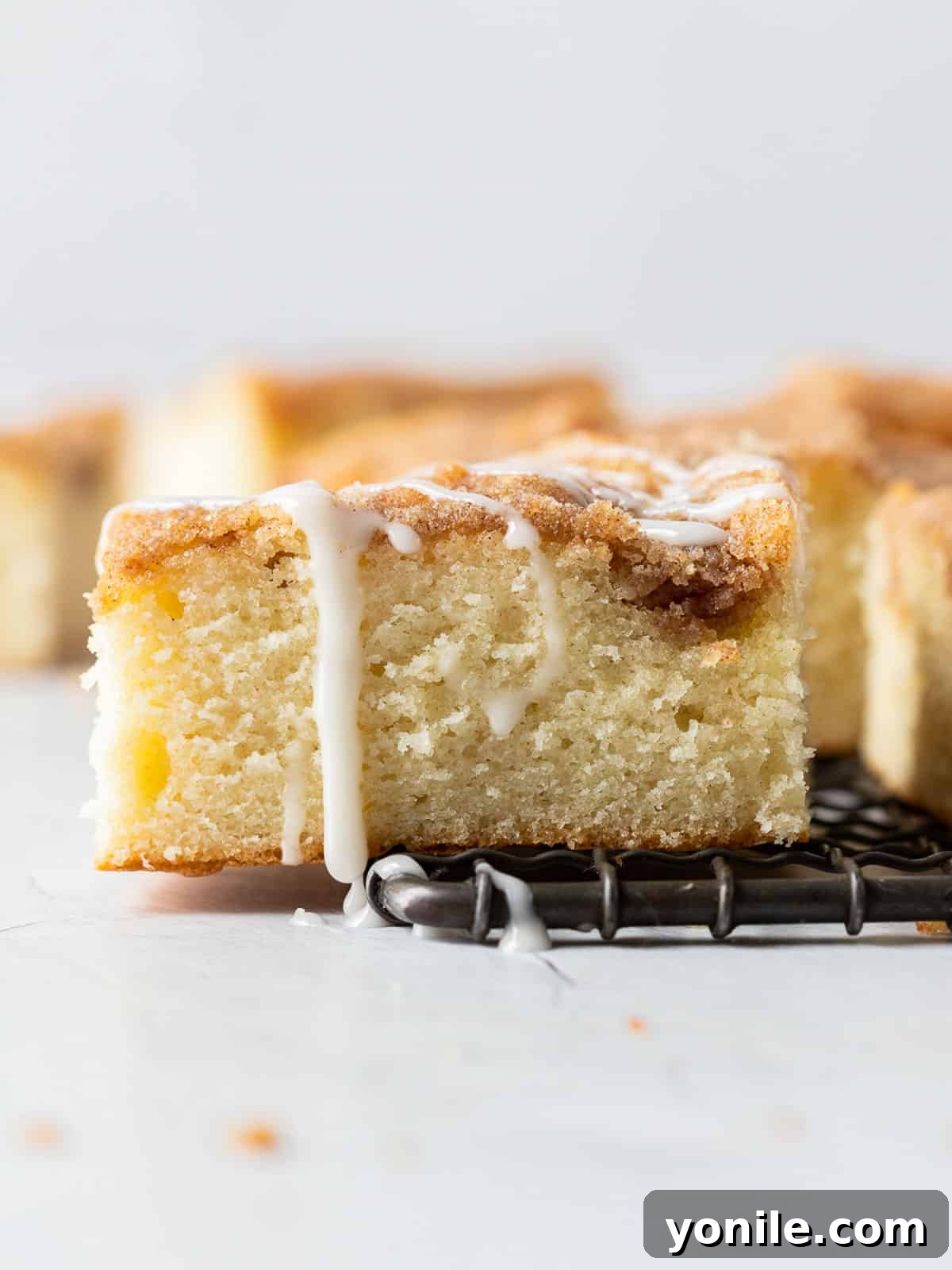 A single piece of freshly baked Cinnamon Streusel Coffee Cake cooling on a wire rack, showing off its perfect golden crust and streusel.