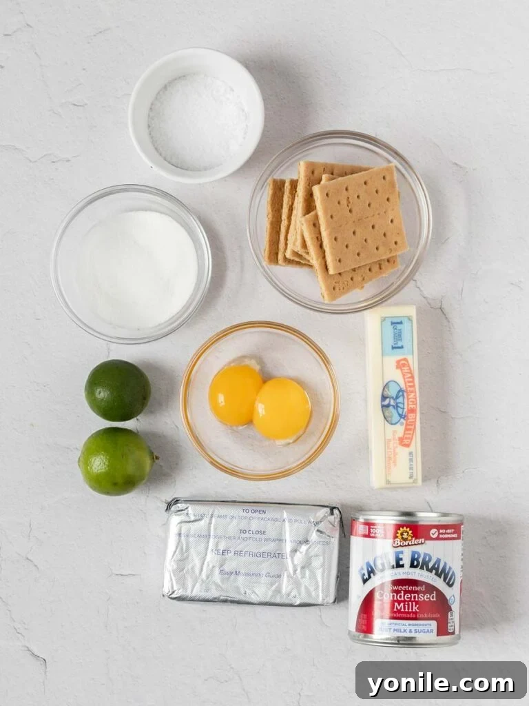A selection of fresh ingredients laid out on a table, including unwrapped cream cheese, whole limes, eggs, and a can of sweetened condensed milk, ready for making Key Lime Pie Bars.