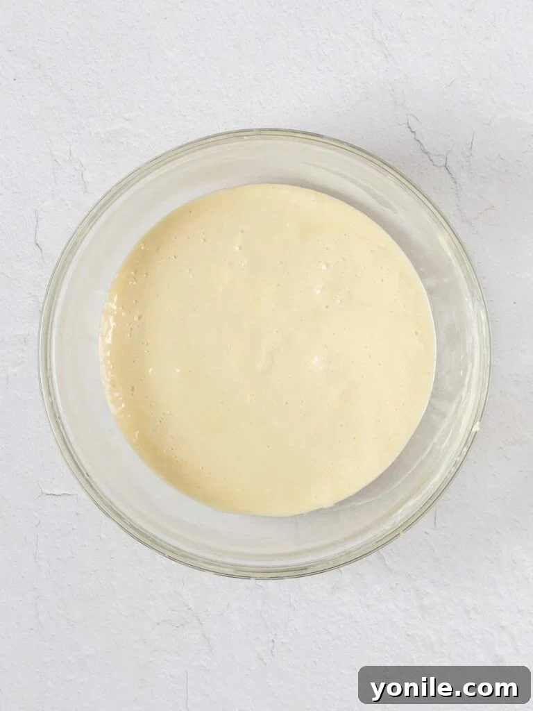 A bowl filled with smooth, pale yellow Key Lime Pie filling, ready to be poured over the crust.