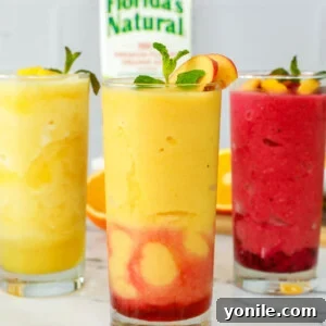 Three glasses of orange juice slushies, beautifully presented and garnished.
