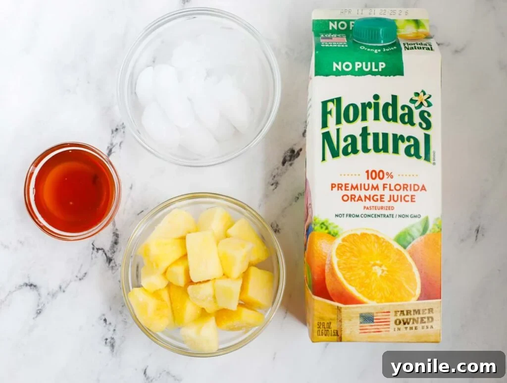 A selection of fresh and frozen ingredients, including pineapple chunks, orange juice, and honey, neatly arranged for making a delicious pineapple smoothie.