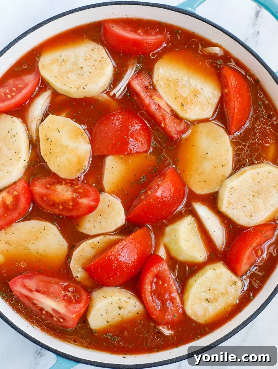 Lebanese Kofta Stew for Beginners 11 A pot filled with potatoes, tomatoes, and kafta patties, gently simmering in a rich red sauce.