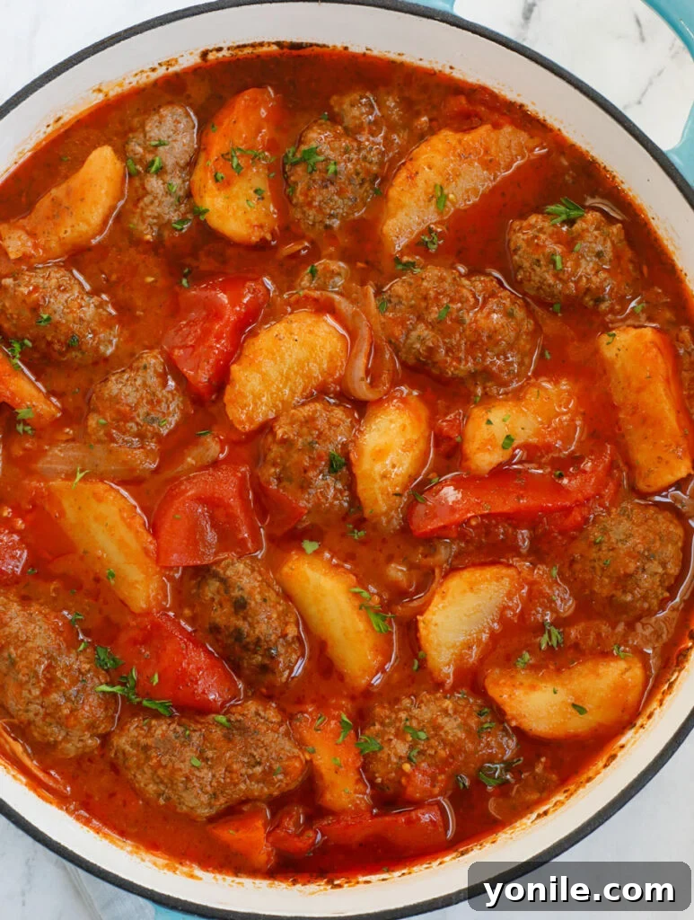 Lebanese Kofta Stew for Beginners 13 Kafta and potato stew bubbling in a rustic Dutch oven on a stovetop.