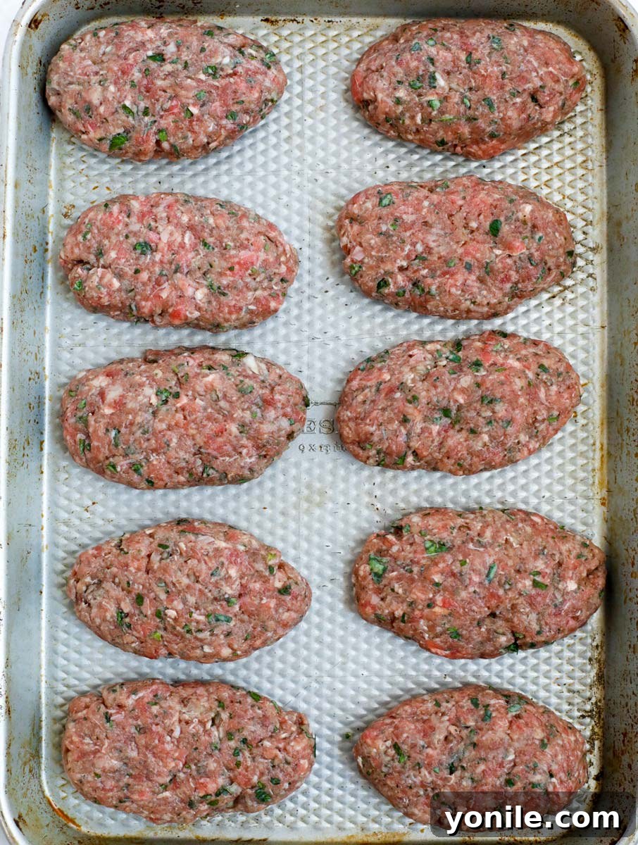 Lebanese Kofta Stew for Beginners 6 Freshly formed kafta patties arranged neatly on a baking sheet, ready for cooking.