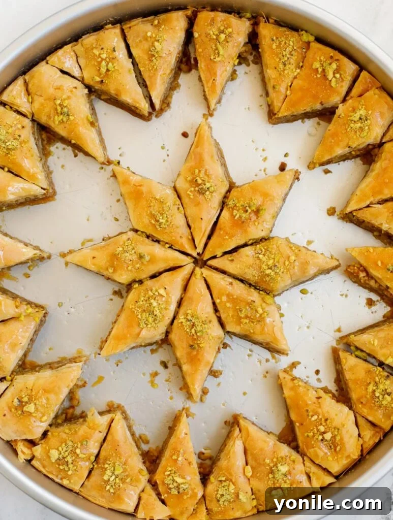 A large tray of golden walnut baklava with several pieces already cut and removed, showcasing its flaky layers and rich nut filling.