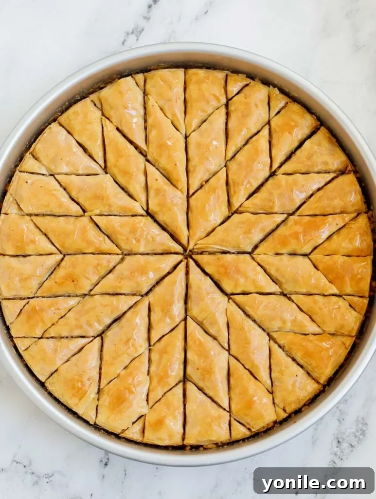 A beautifully baked tray of walnut baklava, already cut into glistening diamond shapes, fresh from the oven.