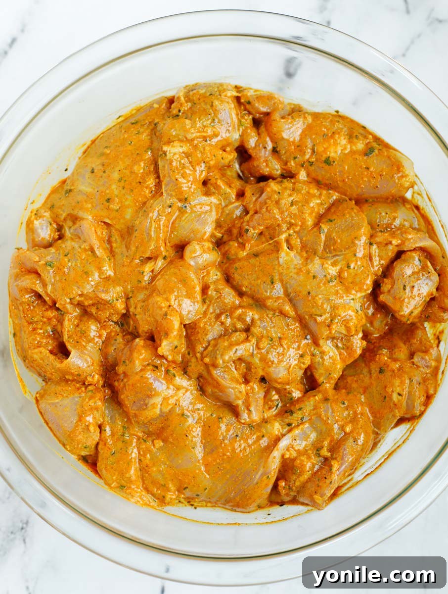 Chicken marinating in a bowl.