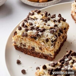 A side view of an Almond Joy Cheesecake Bar, highlighting its distinct layers and appealing texture.