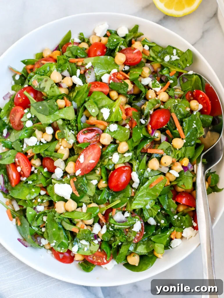 A beautifully arranged plate of vibrant spinach and chickpea salad, showcasing fresh ingredients.