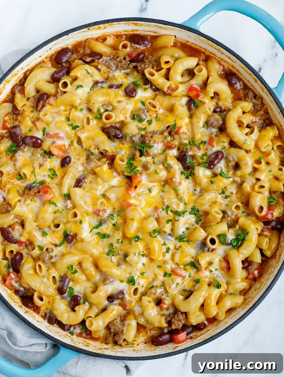 Overhead view of a pot of chili mac and cheese, steam rising, ready to be served.