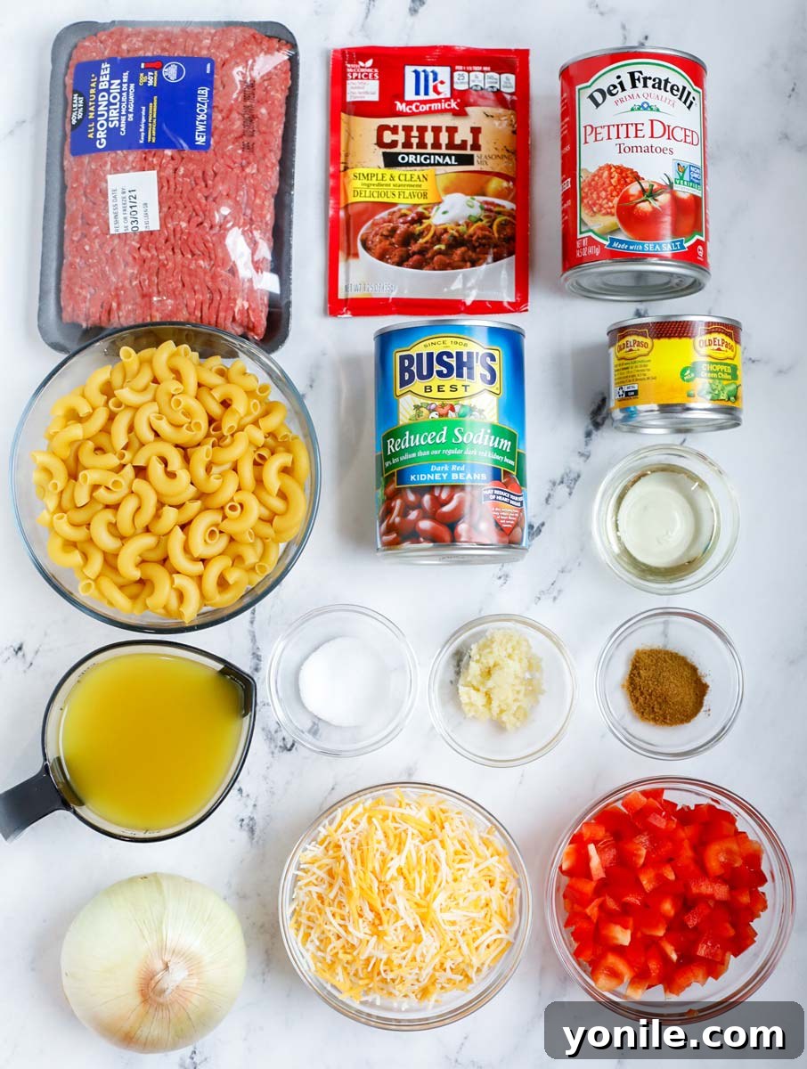 All the fresh ingredients laid out before cooking chili mac and cheese, including diced vegetables, ground meat, and various spices.