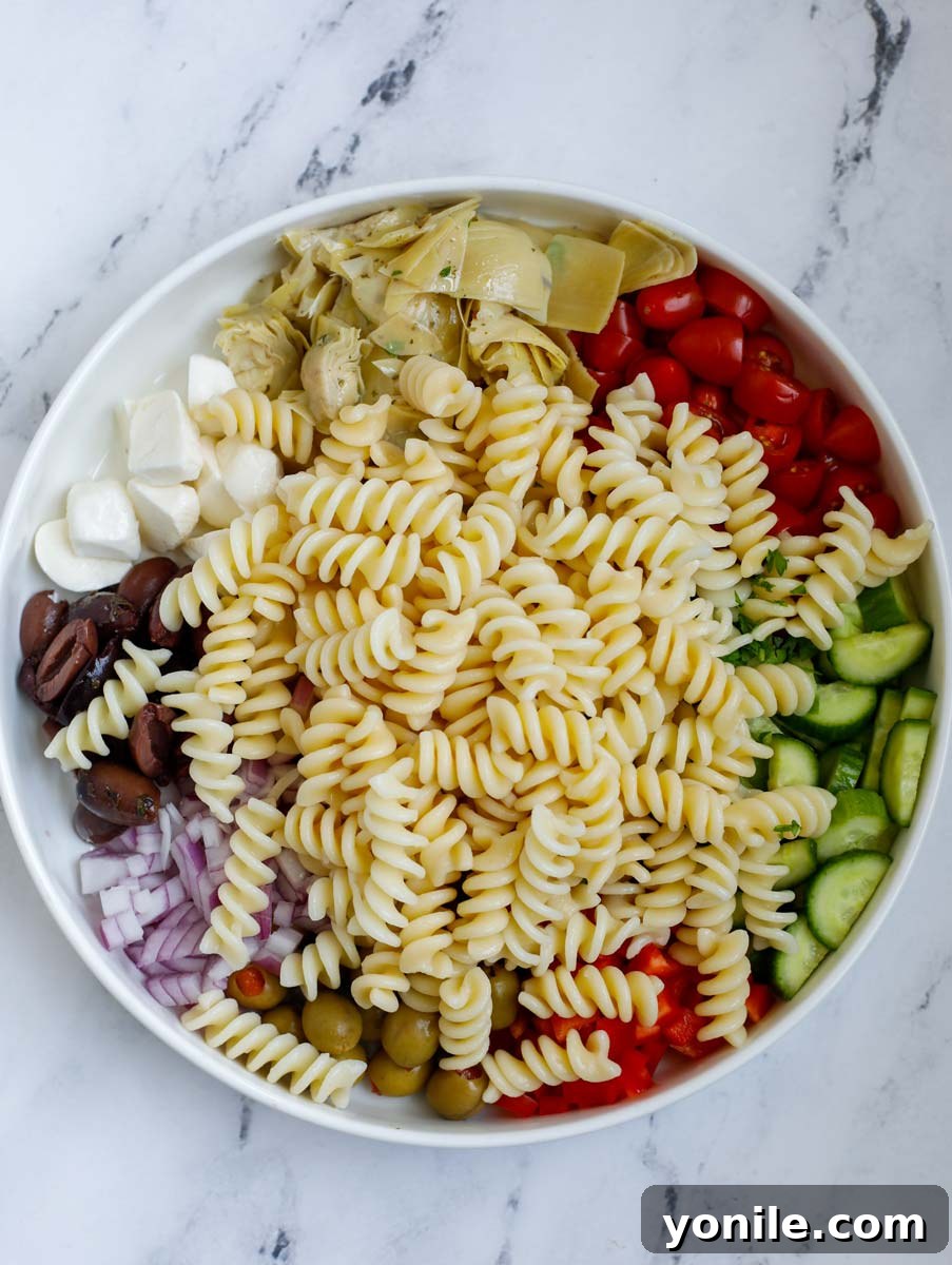 Vibrant Mediterranean Pasta Medley 6 A close-up of the mixed ingredients for the pasta salad in a large bowl.
