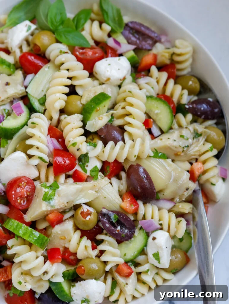 Vibrant Mediterranean Pasta Medley 8 A close-up view of the perfectly tossed Mediterranean pasta salad in a bowl.