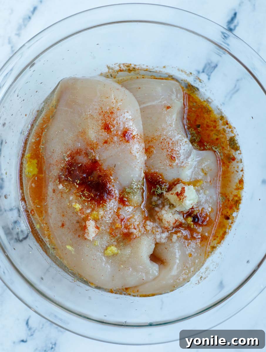 Crispy Rosemary Air Fryer Chicken 4 A bowl of chicken breasts with marinate.