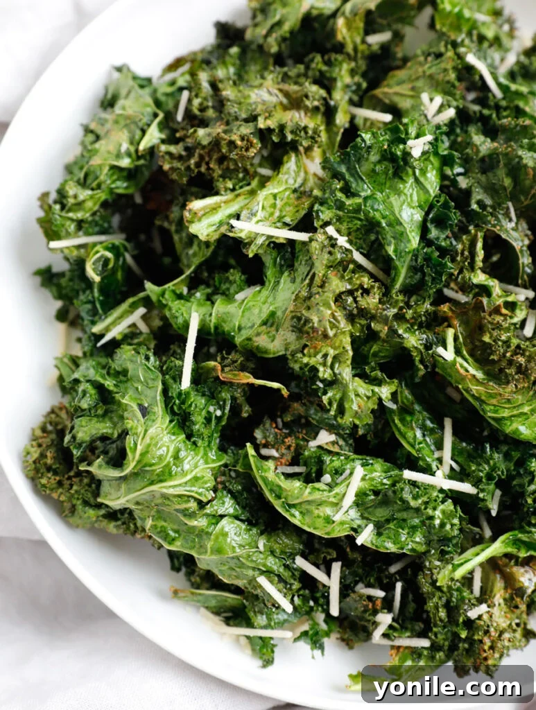 Golden Air Fryer Kale Crisps 8 A close-up shot of crispy, seasoned kale chips piled high in a white ceramic bowl, ready to be devoured.