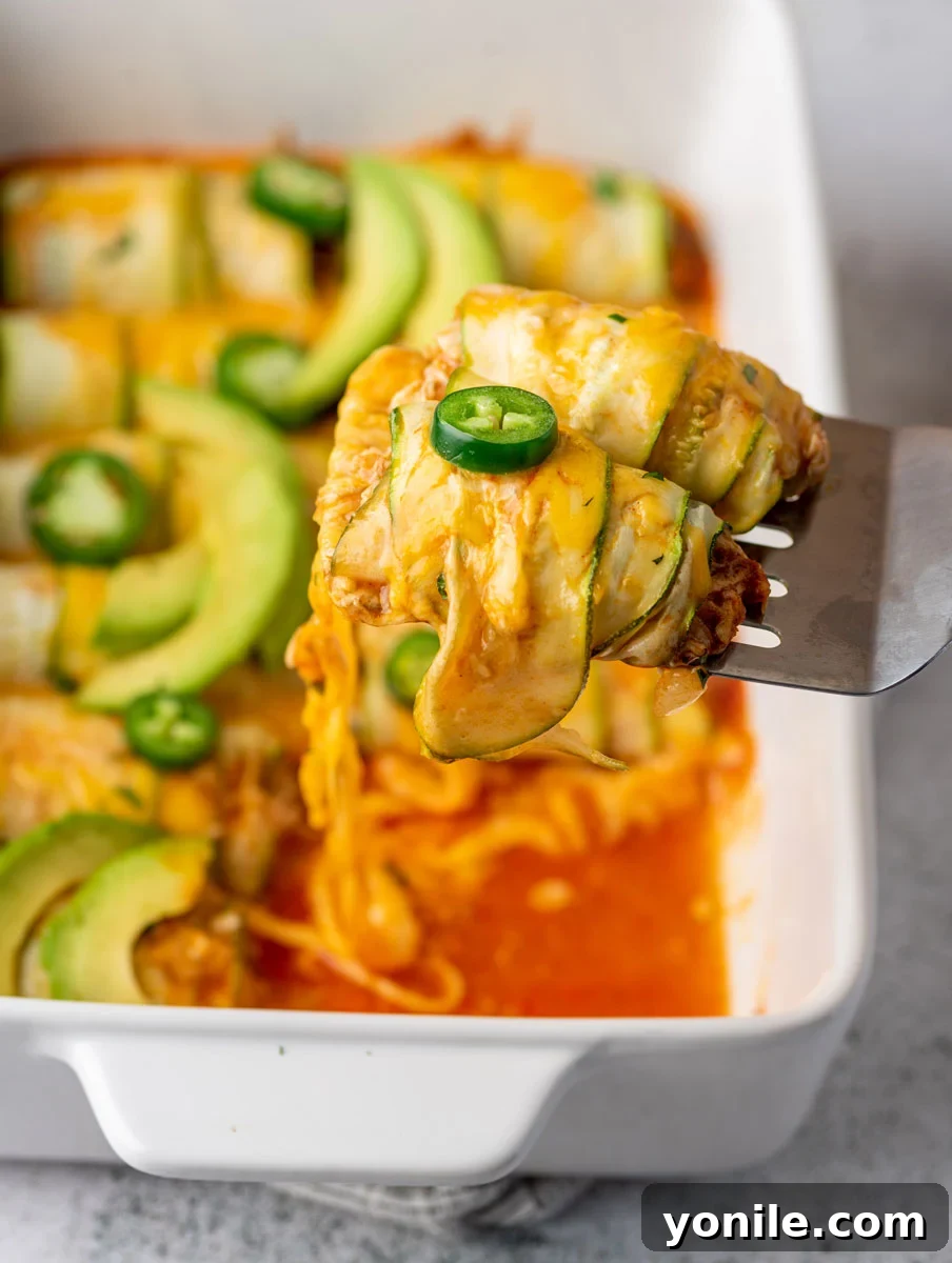 chicken enchilada scooped up with a spoon, highlighting the zucchini strips