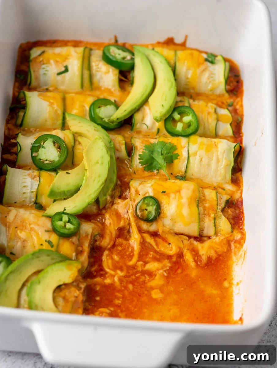chicken enchiladas in a baking dish after baking, with a few pieces removed