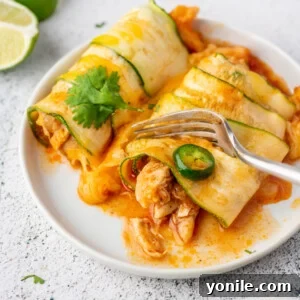 a fork cutting into a piece of chicken zucchini enchiladas
