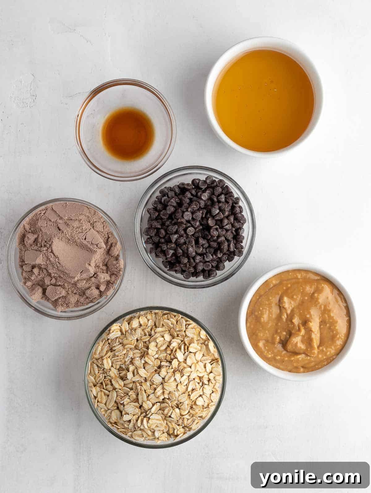 A collection of fresh ingredients for energy balls, including oats, peanut butter, and chocolate chips, neatly arranged on a counter.