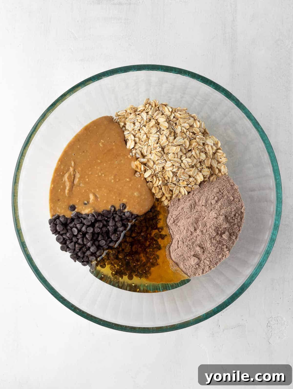 Ingredients for protein balls in a bowl, ready to be mixed into a uniform dough.