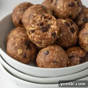protein bites in a bowl with a bite taken out of one.