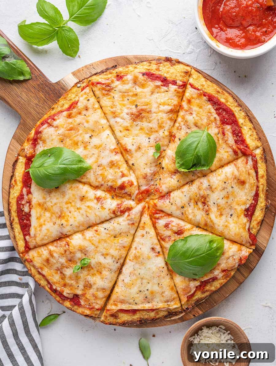 top down shot of cauliflower pizza with basil leaves on top