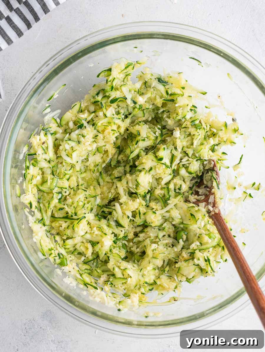 Crispy Zucchini Bites 6 The zucchini fritter mixture thoroughly combined in a glass bowl.