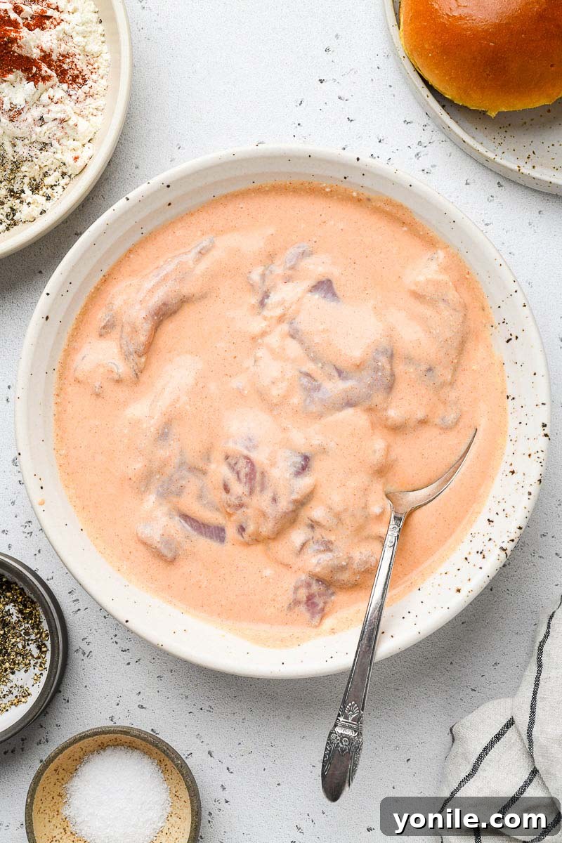 Chicken thighs soaking in a buttermilk marinade.