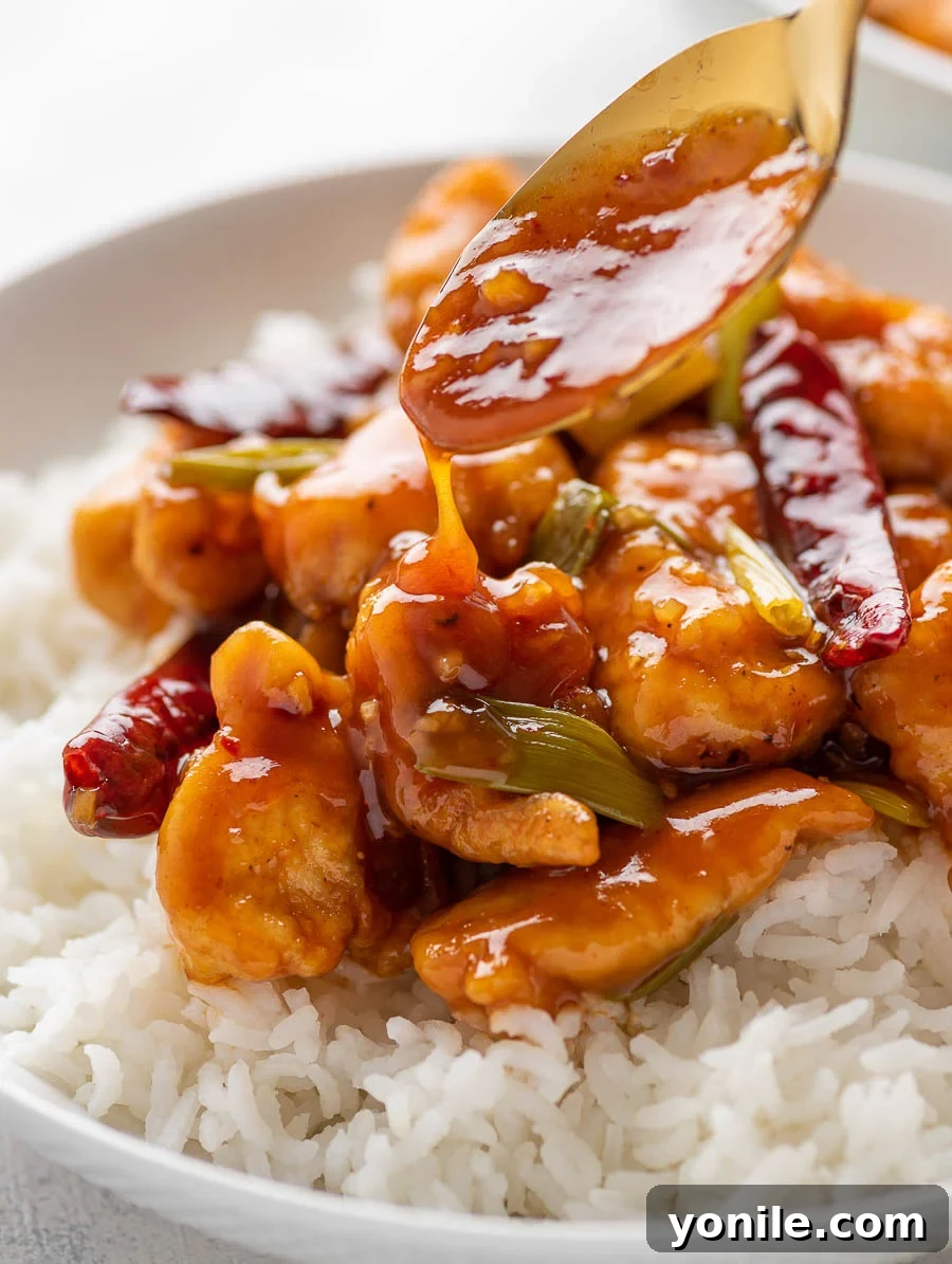 No-Fuss Mongolian Chicken 9 Mongolian sauce being generously poured over crispy chicken in a skillet