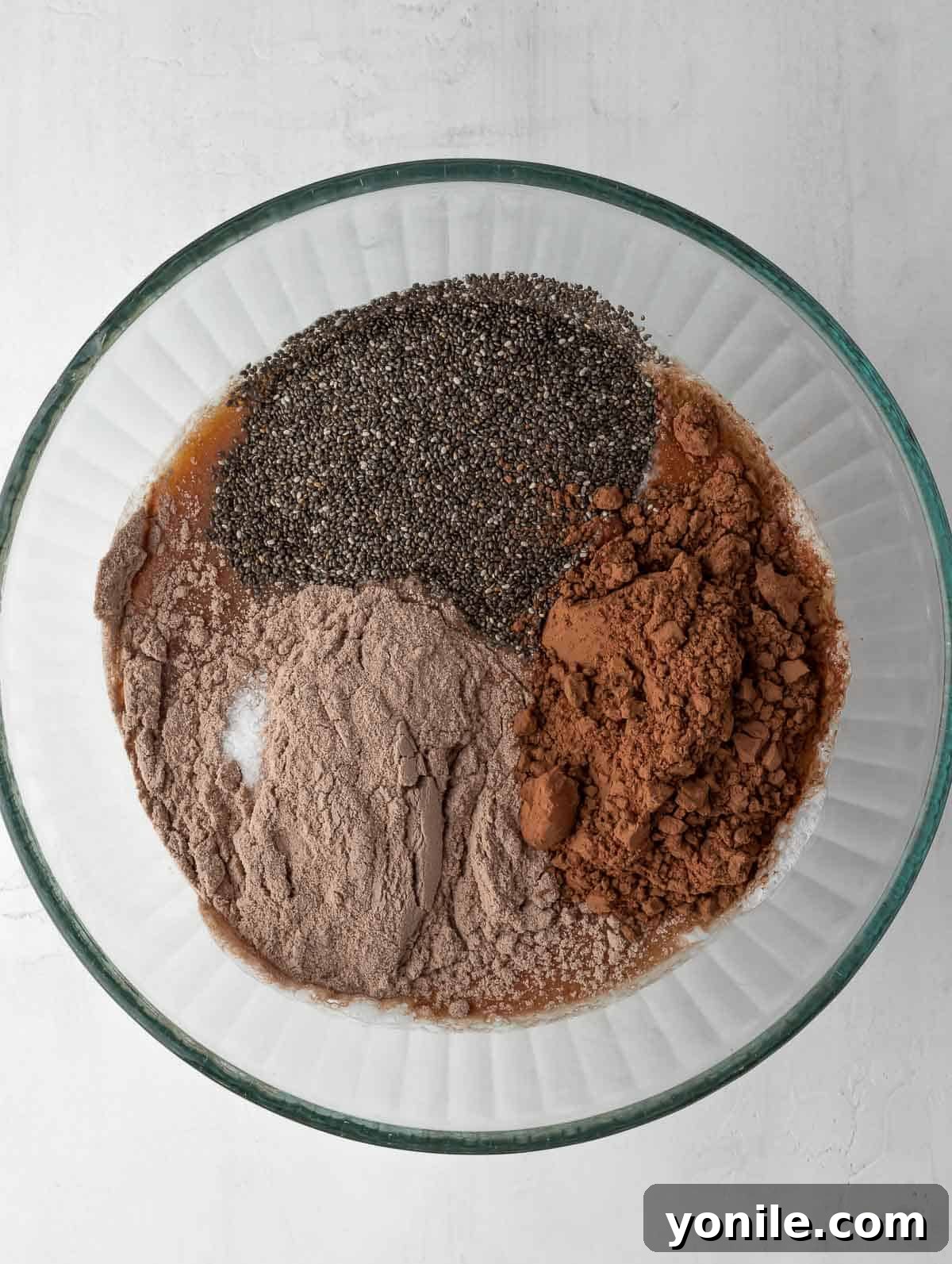 All the dry and wet ingredients for the chocolate protein chia pudding are combined in a bowl, stirred and ready to rest.
